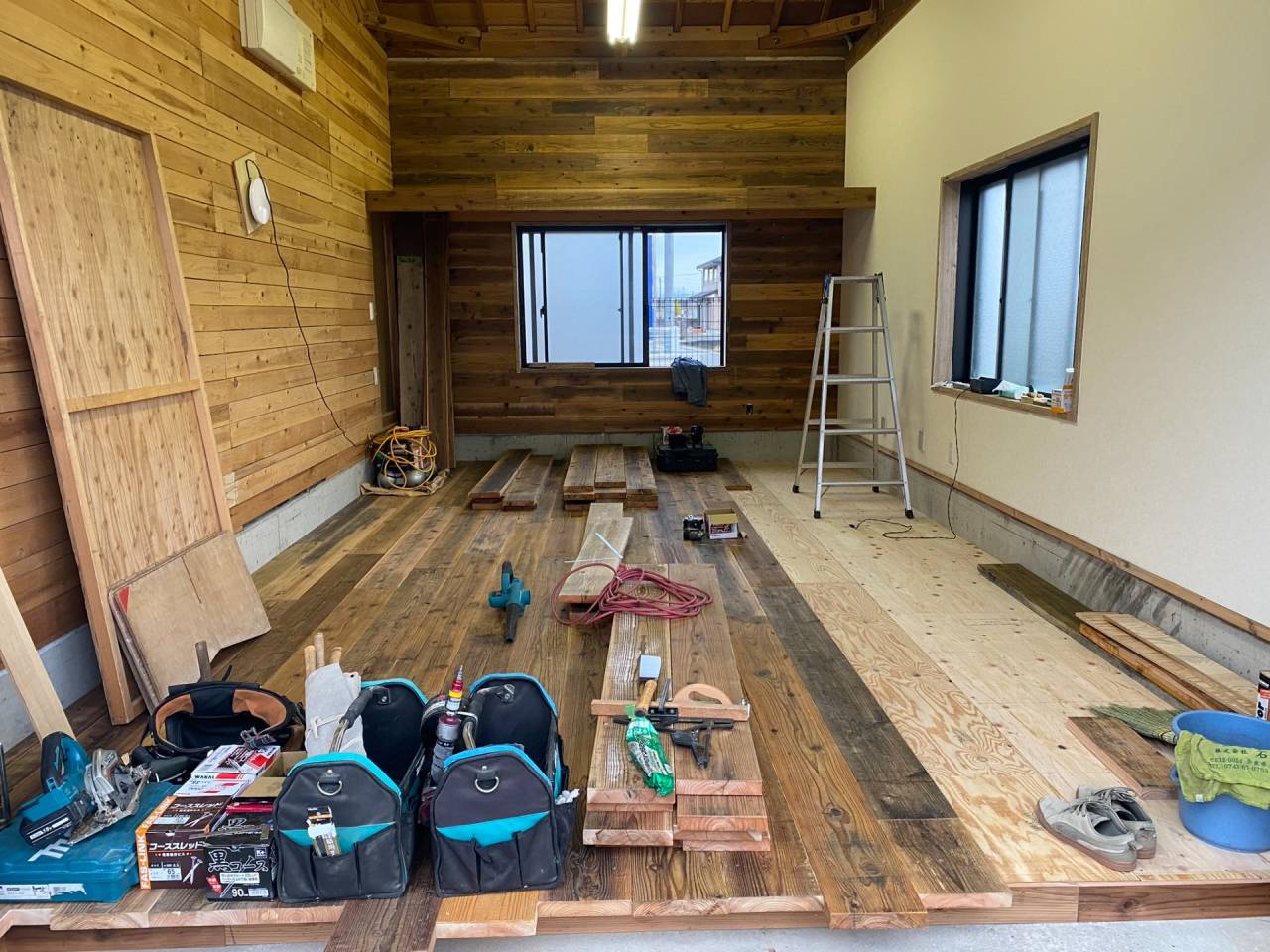 工事途中状況・壁クロス施工後床工事へと移ります。床の水平や不陸を調整し捨て張り合板施工後に足場板古材の床板を張っていきます。